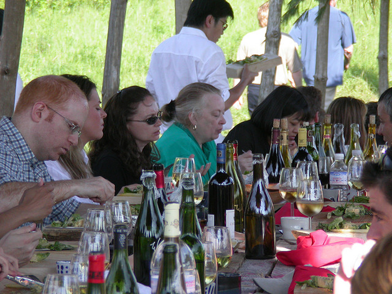 RGB query scene with people seated at a table full of bottles and glasses